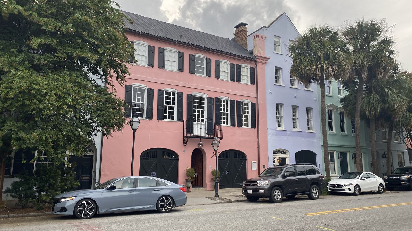 Pastel pink and lavender historic row houses with palm trees on East Bay Street, Charleston