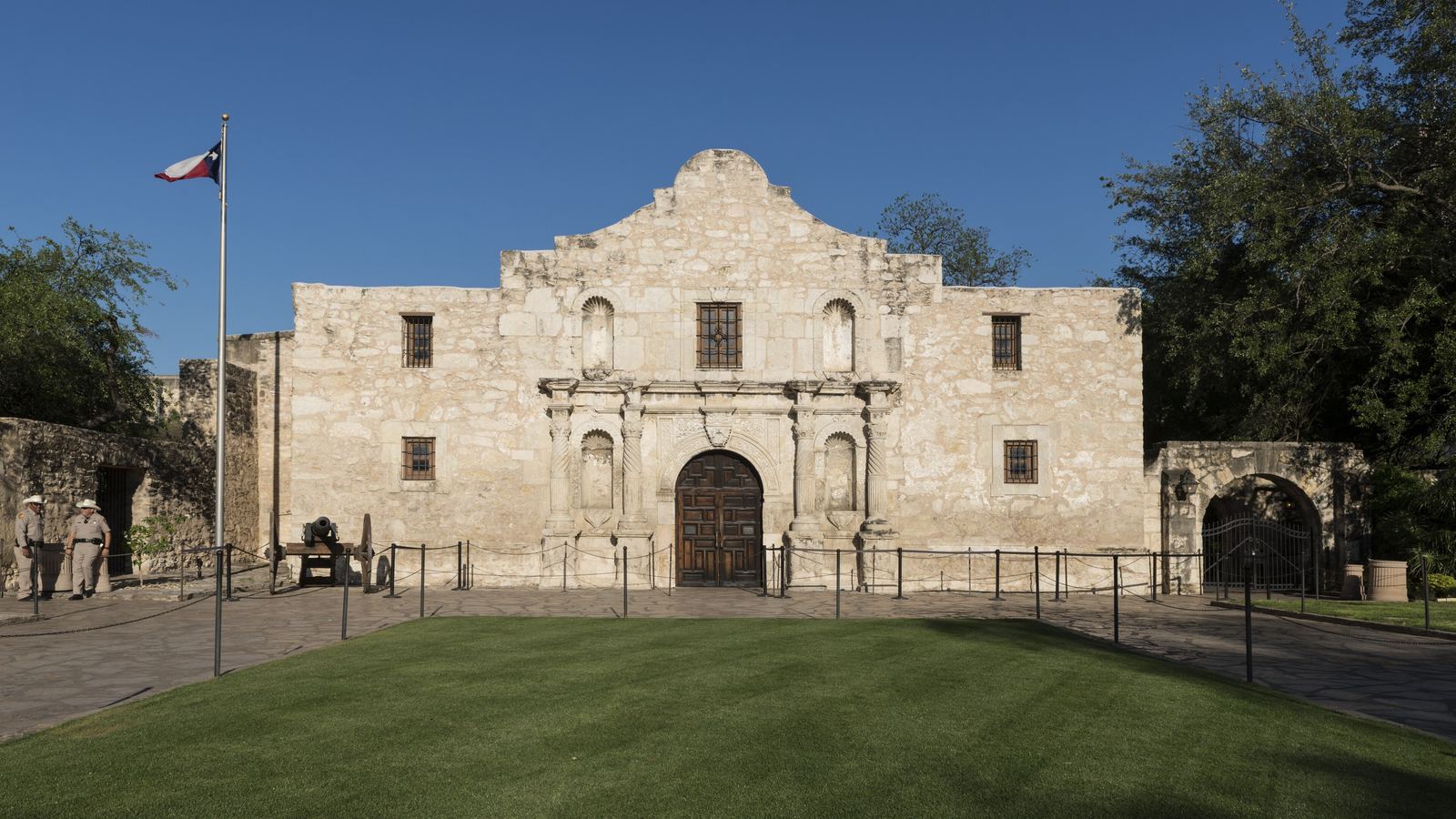 The limestone facade of the Alamo church in San Antonio under a clear blue sky