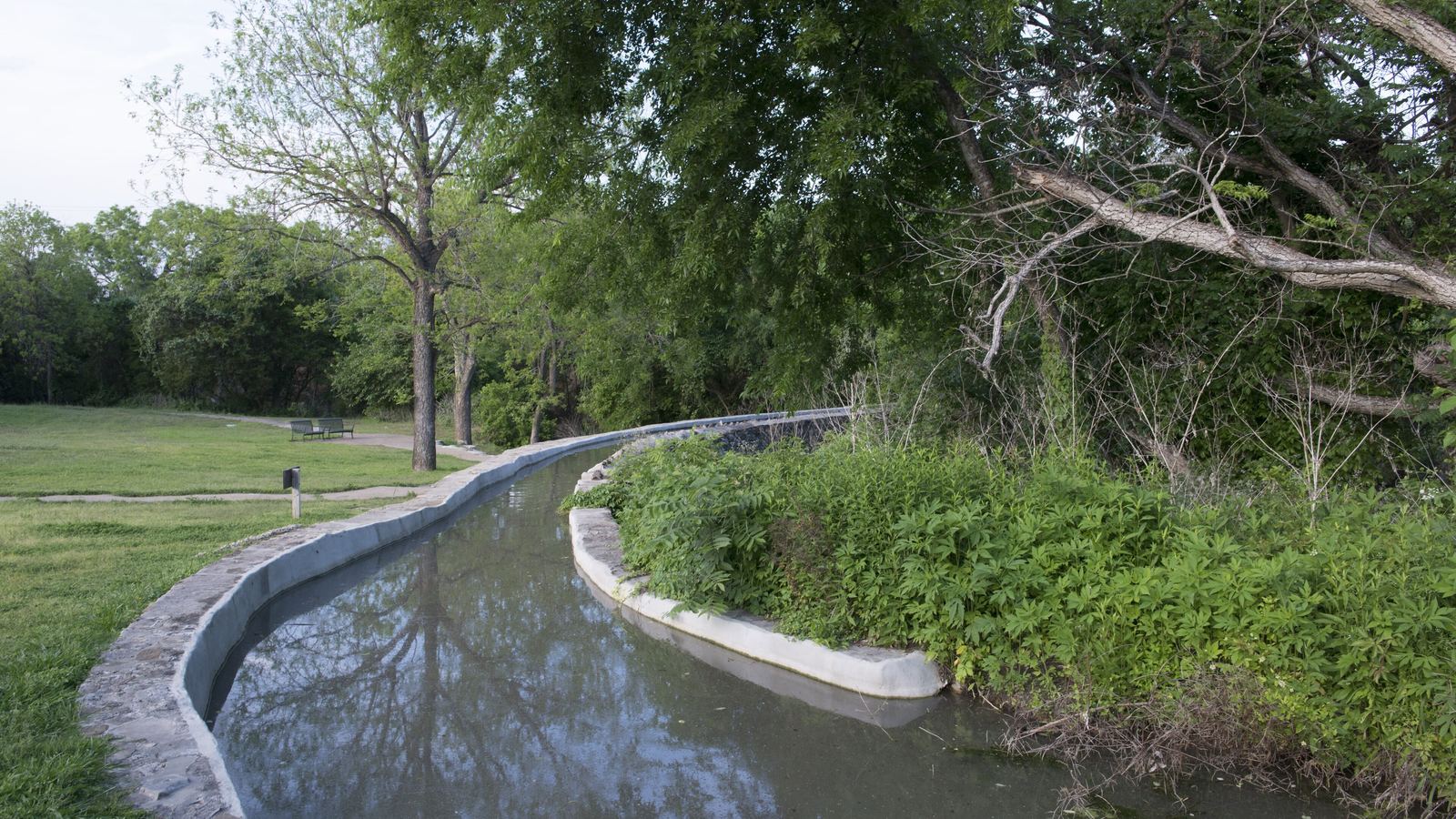 The 18th-century Espada Aqueduct carrying an irrigation channel through green parkland in San Antonio