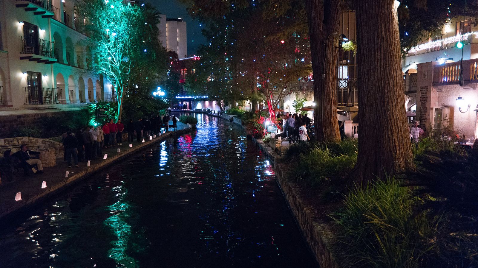 Holiday lights reflected in the San Antonio River at night along the River Walk